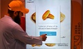 無料のパンを自動で提供する機械を利用する男性。アラブ首長国連邦（UAE）のドバイで（2022年9月22日撮影）。(c)Karim SAHIB / AFP