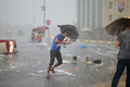 トルコの最大都市イスタンブールで、激しい雨とひょうが降る中、傘を手にする人（2017年7月27日撮影）。(c)AFP/YASIN AKGUL