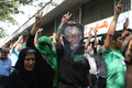 イランの首都テヘラン（Tehran）で、大統領選で敗退したミルホセイン・ムサビ（Mir Hossein Mousavi）元首相の顔写真を掲げ行進する改革派支持者の人びと（2009年9月18日撮影）。(c)AFP/ATTA KENARE