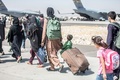 アフガニスタンの首都カブールの空港で、飛行機へ向かう避難民ら。米海兵隊提供（2021年8月24日撮影）。(c)AFP PHOTO / SAMUEL RUIZ / US MARINE CORPS/HANDOUT
