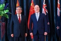 ニュージーランドのクリストファー・ラクソン首相と並んで写真撮影に臨む中国の李強首相（左）。ニュージーランド首都ウェリントンで（2024年6月13日撮影）。(c)Hagen Hopkins / POOL / AFP