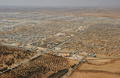 シリア国境から約8キロのヨルダン領内にあるザータリ難民キャンプ（Camp Zaatari）の空撮写真。

1年前に開設されたザータリ難民キャンプには、よりどころを無くした11万5000人のシリア難民が暮らしている。商才に長けた難民たちは、キャンプの電気網を「拝借」してキャンプ内のわずかな舗装道路に立ち並ぶ約3000軒の店舗や、580軒の料理店や屋台に電気を引いており、国連難民高等弁務官事務所（UNHCR）に届く電気代は毎月50万ドル（約5000万円）に上る（2013年7月18日撮影）。(c)AFP/MANDEL NGAN