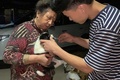 中国南西部成都で、保護された犬のケアをするボランティア。成都愛の家動物救助センター提供（2021年5月5日撮影、7日提供）。(c)AFP PHOTO / Chengdu Aizhijia Animal Rescue Centre