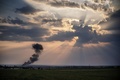 ウクライナ東部のドネツク（Donetsk）から北東に約40キロのジュダニフカ（Zhdanivka）で、撃墜されたウクライナ軍の戦闘機の残骸から上がる煙（2014年8月7日撮影）。(c)AFP/DIMITAR DILKOFF