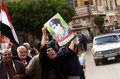 エジプト・カフルエルシェイク（Kafr el-Sheikh）の投票所の外でブデルファタフ・サイード・シシ（Abdel Fattah Said al-Sisi）軍最高評議会議長兼国防相の写真を掲げる女性（2014年1月14日撮影）。(c)AFP/MOHAMED ABDELWAHAB