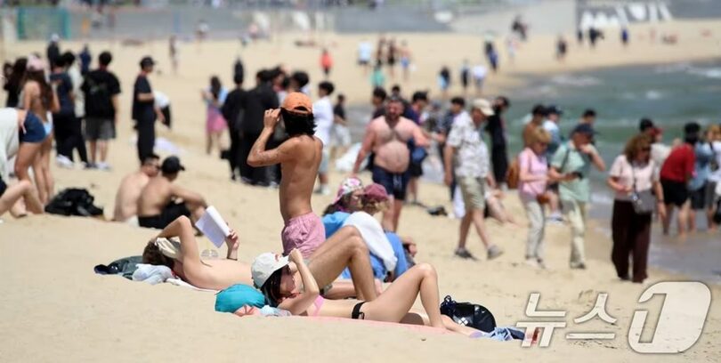 釜山海雲台海水浴場を訪れ、日焼けを楽しむ外国人観光客(c)news1