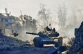 シリア北部アレッポ旧市街で、新たに奪還した地域を戦車で走る政府軍側の部隊（2016年12月8日撮影）。(c)AFP/GEORGE OURFALIAN
