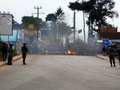 マダガスカル・アンタナナリボ（Antananarivo）で、路上に築かれ炎上するバリケードを遠巻きに見つめる機動隊（2010年11月17日撮影）。(c)AFP/ALINE RANAIVOSON