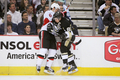 セネターズのウェイド・レデン（%%Wade Redden%%）とフェンス際で競り合うペンギンズのシドニー・クロスビー（%%Sidney Crosby%%、右）。(c)AFP/Getty Images/Jamie Sabau