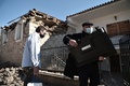 ギリシャ中部テッサリア地域のダマシ村で、地震により損壊した建物から物を持ち出す男性（2021年3月3日撮影）。(c)Sakis MITROLIDIS / AFP