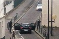 仏パリ（Paris）にある風刺週刊紙シャルリー・エブド（Charlie Hebdo）の本社付近で警察官と対峙する武装した2人の男（2015年1月7日撮影）。(c)AFP/ANNE GELBARD