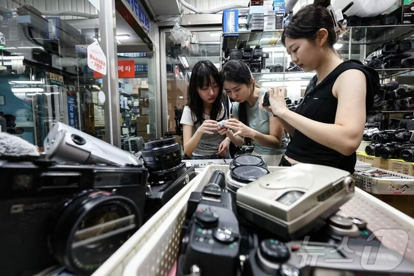 ソウル・鍾路区の世運商街にある中古カメラ店で、旧型デジタルカメラを見る客ら＝2024年7月22日(c)news1
