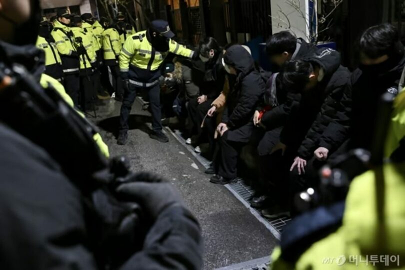 18日午後、ソウル西部地裁の塀を越えて侵入し、警察に検挙された若者ら＝共同取材(c)MONEYTODAY