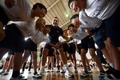 熊本市内の小学校を訪れ、児童たちにスクラムを指導するフランスのギレム・ギラド（中央、2019年9月26日撮影）。(c)FRANCK FIFE / AFP