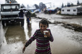 雨の中、ぬかるんだキャンプの中を歩く少女。(c)AFP/Bulent Kilic