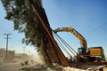 メキシコのバハカリフォルニア州メヒカリで、強風により倒れた国境壁に対応する作業員（2020年1月29日撮影）。(c)AFP