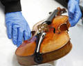 パリ（Paris）の音楽博物館（Museum of Music）で、アントニオ・ストラディバリ（Antonio Stradivari）が製作したバイオリンを調べる研究者（2009年12月3日撮影）。(c)AFP/PATRICK KOVARIK