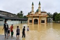 タイ南部ナラティワット県で、浸水したモスク（イスラム礼拝所）の周りで遊ぶ少年たち（2022年12月19日撮影）。(c)Madaree TOHLALA / AFP