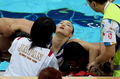 シンクロナイズドスイミング、チーム・フリールーティン決勝終了後、係員に救助される小林寛美。（2008年8月23日撮影）(c)AFP/Greg WOOD