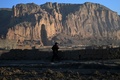 アフガニスタンのバーミヤン渓谷にある遺跡の跡地を歩く少数民族ハザラ人の男性（2021年3月5日撮影）。(c)WAKIL KOHSAR / AFP
