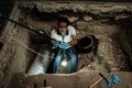 ブラジル・リオデジャネイロの新黒人記憶・研究博物館にある米州最大の奴隷墓地で遺骨を採取するフルミネンセ連邦大学の考古学者（2017年5月5日撮影）。(c)AFP/YASUYOSHI CHIBA