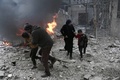 シリア政府軍とロシア軍によるものとされる爆撃があったシリア首都ダマスカス近郊の東グータで、走って避難する市民（2018年1月6日撮影）。(c)AFP PHOTO / ABDULMONAM EASSA