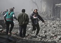シリア首都ダマスカス近郊の東グータで行われた政府軍の爆撃で負傷し、がれきの中から救出された子どもを抱えて走る男性（2018年2月19日撮影）。(c)AFP PHOTO / ABDULMONAM EASSA