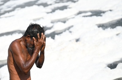 汚染された川で水浴び、水面には泡 インド