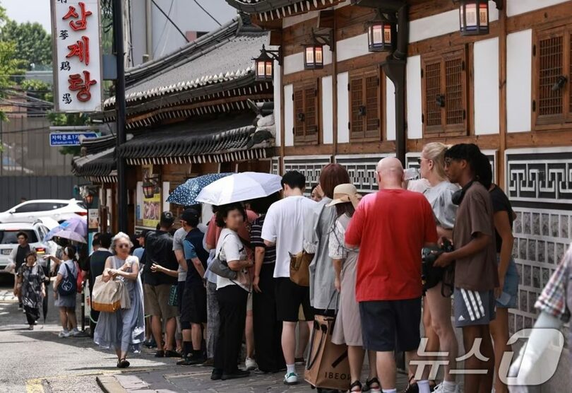 初伏の15日、ソウル・鍾路区のサムゲタン専門店前で入店を待つ市民や観光客(c)news