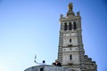 仏マルセイユのノートルダムドラガルド大聖堂で、パリ五輪の聖火トーチを手にするサッカー元フランス代表のバジール・ボリ氏（2024年5月9日撮影）。(c)CHRISTOPHE SIMON / AFP