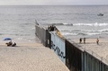 メキシコ・プラヤスデティフアナから見た、米国側の国境フェンスを補強する作業員と付近の警備に当たる米兵（2018年11月15日撮影）(c)ALFREDO ESTRELLA / AFP