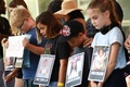 米テキサス州ヒューストンで開催された全米ライフル協会（NRA）年次総会の会場前で、小学校乱射事件で犠牲となった児童の写真を手に抗議に参加する子どもたち（2022年5月22日撮影）。(c)Patrick T. FALLON / AFP