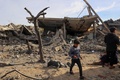 パレスチナ自治区ガザ地区ラファで、イスラエル軍の爆撃を受けた建物のそばで遊ぶ子どもたち（2024年2月12日撮影）。(c)SAID KHATIB / AFP