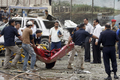 車両を使った自爆攻撃を受けたイラクの首都バグダッド（Baghdad）市行政庁舎から運び出される遺体（2009年10月25日撮影）。(c)AFP/SABAH ARAR