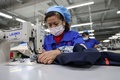 北京冬季五輪の関係者が着用する防護服を作る作業員。中国・山東省浜州市で（2022年1月27日撮影）。(c)AFP