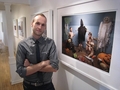 カナダ・オタワ（Ottawa）で開かれた展示「遊戯室にて（In the Playroom）」で、旧アブグレイブ刑務所（Abu Ghraib）での「拷問」を子どもたちが再現した写真の前に立つ写真家のジョナサン・ホビン（Jonathan Hobin）氏（2010年10月9日撮影）。(c)AFP/Michel Comte