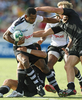 タックルを受けながらも突破を試みるフィジーの%%Setefano Cakau%%。(c)AFP/Greg WOOD