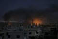 シリア南部ダルアーの反体制派掌握地域で政府軍が実施した空爆によるとみられる煙と炎（2017年7月3日撮影）。(c)AFP/Mohamad ABAZEED