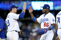 13MLBプレーオフ、ナ・リーグ地区シリーズ（5回戦制）、ロサンゼルス・ドジャース（Los Angeles Dodgers）対アトランタ・ブレーブス（Atlanta Braves）第3戦。勝利を収めハイタッチを交わすロサンゼルス・ドジャースのエイドリアン・ゴンザレス（Adrian Gonzalez、左）とヤシエル・プイグ（Yasiel Puig、2013年10月6日撮影）。(c)AFP/Getty Images/Stephen Dunn