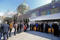 イラン・テヘラン郊外で、国会選挙で票を投じるため列をつくる人々（2020年2月21日撮影）。(c)ATTA KENARE / AFP
