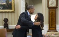 米ワシントンD.C.（Washington D.C.）ホワイトハウス（White House）の大統領執務室（Oval Office）で、エボラ出血熱から回復した看護師のニーナ・ファム（Nina Pham）さん（右）を抱きしめるバラク・オバマ（Barack Obama）米大統領（左、2014年10月24日撮影）。(c)AFP/Saul LOEB