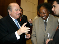 写真は、CAFの役員カマール・シャダド氏（%%Kamal Shadad%%、右2）と話をするブラッター会長（左）。(c)AFP/ISAM AL-HAJ