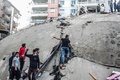 トルコのイズミルで、地震により倒壊した建物で行方不明者の捜索を行う人々（2020年10月30日撮影）。(c)MERT CAKIR / AFP