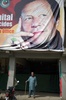 パキスタン・イスラマバードで、パキスタン正義運動（PTI）のイムラン・カーン党首の横断幕の下に立つ男性（2018年7月26日撮影）。(c)AFP PHOTO / AAMIR QURESHI