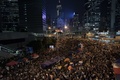 香港（Hong Kong）・金鐘（アドミラルティ、Admiralty）地区で、大画面に映し出された、民主派デモを率いる学生団体の代表と香港政府側の対話の生中継を視聴するデモの参加者ら（2014年10月21日撮影）。(c)AFP/Nicolas ASFOURI
