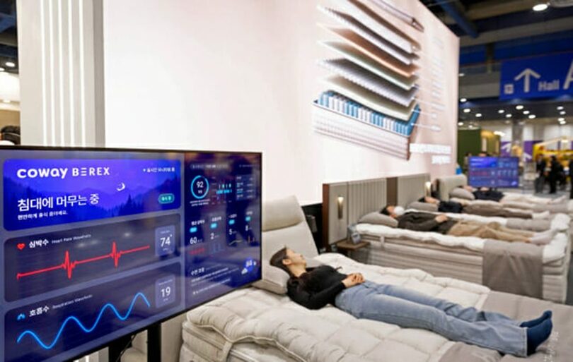 来場者がコーウェイ「ビレックス 睡眠センサーマットレスSシリーズ」を体験しながら、呼吸・心拍などのデータを確認している。スマートウォッチのようなウェアラブル機器を着用する必要はなく、ベッドに横になるだけで内蔵センサーが心拍などを感知し、個人の睡眠管理をサポートする＝コーウェイ(c)KOREA WAVE
