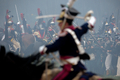 フランス皇帝ナポレオン（Napoleon）の遠征軍と帝政ロシア軍が激戦を繰り広げた1812年の「ボロジノの戦い」から今年で200年となることを記念し、モスクワ（Moscow）西方のボロジノ（Borodino）で2日、戦いを再現するイベントが行われた。

　当時の軍服や刀剣などを用いて戦いを忠実に再現したイベントには、ロシア政府が110万ドル（約8700万円）を出資。フランス側1550人、ロシア側1450人の兵士を演じる計3000人が参加。ジスカール・デスタン（Giscard d&apos;Estaing）仏元大統領と、ウラジーミル・プーチン（Vladimir Putin）露大統領も「観戦」に訪れた。これに先立ち、プーチン大統領の補佐官は「ボロジノの戦い」再現イベントを「若者の愛国教育」を広めるために活用したいと述べた。

　1812年9月7日の「ボロジノの戦い」は合戦では勝利しながら、戦争には負けた戦将の際立った例だ。

　ボロジノでは2万人のナポレオン軍が激戦の末に、兵力の多い4万5000人の露軍を破った。しかし痛手が大きかったため、ナポレオンはモスクワに進軍を開始する前に回復期間を置くことにした。この時にナポレオンはおそらく、敵方のクトゥーゾフ将軍が戦闘の翌日に一時撤退したことを知らなかったとされる。この休息の決断が、ナポレオンにとって致命的な誤算だった。

　帝政ロシア軍は兵力の半分を失っていたが、近くの村落で体制を立て直す時間ができ、戦術を練った。ナポレオン軍が入城したモスクワは、市民は脱出しもぬけの殻で、そこに焦土戦術が追い打ちをかけた。士気を失ったナポレオン軍は退却を余儀なくされた（2012年9月2日撮影）。(c)AFP/Kirill Kudryavtsev