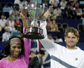 優勝トロフィーを掲げる米国チームのセレーナ・ウィリアムス（左）とマーディー・フィッシュ。(c)AFP/TONY ASHBY