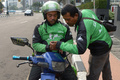 インドネシアのジャカルタで、スマホを確認する新興企業Go-Jekのバイクタクシー運転手たち（2015年6月11日撮影）。(c)AFP/ADEK BERRY