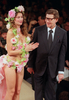 イヴ・サンローラン（Yves Saint Laurent）99年春夏オートクチュール・コレクションのフィナーレに登場したサンローラン氏とモデルのレティシア・キャスタ（Laetitia Casta）（1999年1月撮影）。(c)AFP